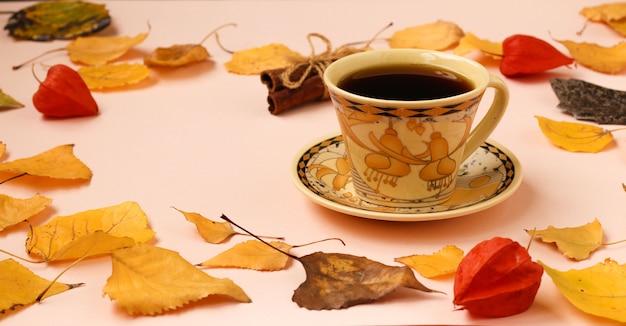 Herfst samenstelling met kopje koffie en kaneelstokjes frame gemaakt van herfstbladeren