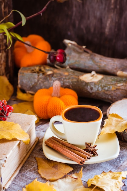 Herfst Stilleven met koffie drinken. Een kopje zwarte koffie en kaneel op een deel van een boom.