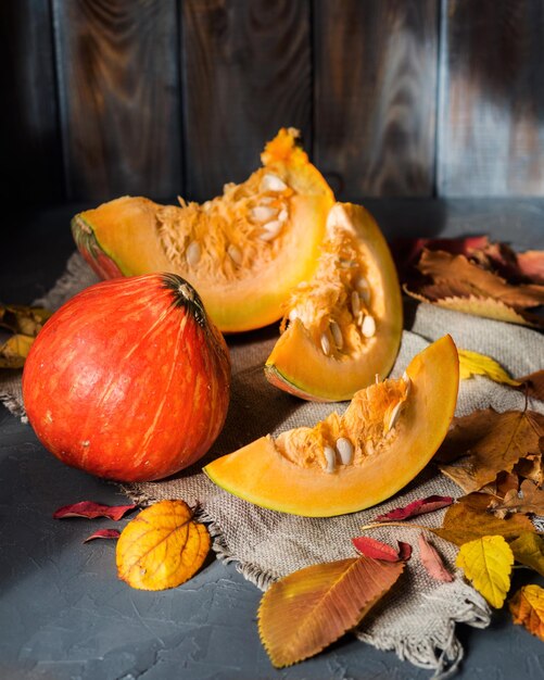 Herfst stilleven Pompoenen en gele bladeren Gehakte stukjes pompoen Herfst achtergrond