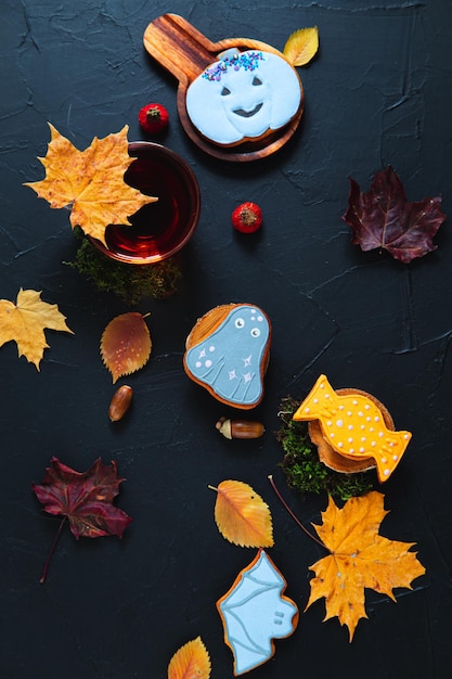 Herfst thee Kopje thee schilderde peperkoek eikels en bladeren op een zwarte achtergrond