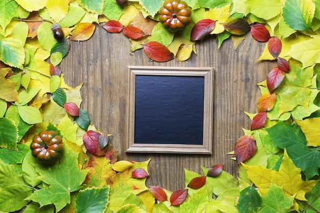 Herfstbladeren achtergrond in vorm van hart op houten tafel