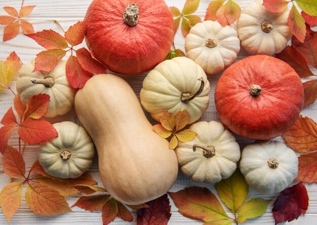 Herfstbladeren en pompoenen over oude houten achtergrond