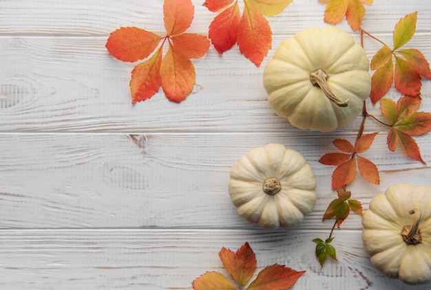 Herfstbladeren en pompoenen over oude houten achtergrond