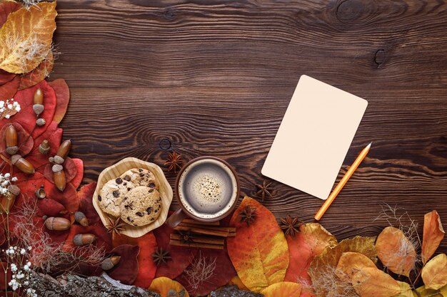 Herfstbladeren, koekjes, thee en wenskaart op hout