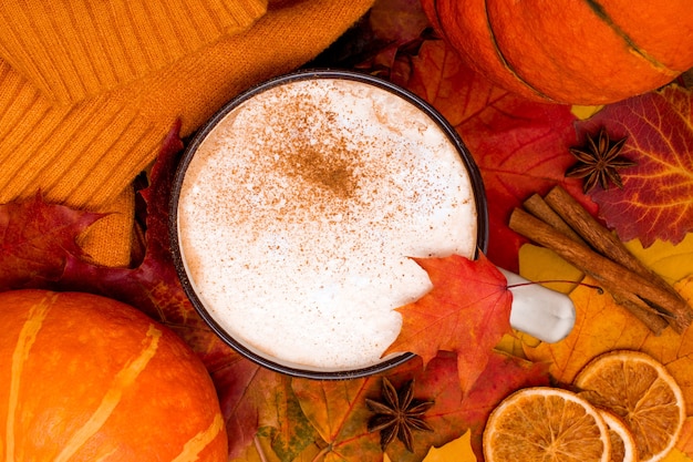 Herfstbladeren met kopje gekruide koffie en knusse trui