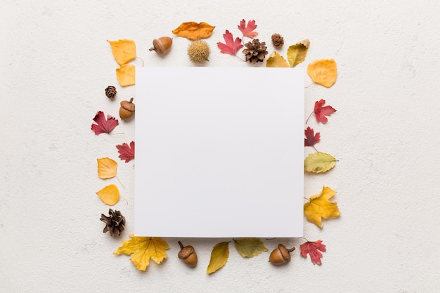 Foto herfstcompositie met blanco papier en gedroogde bladeren op tafel plat lag bovenaanzicht kopieerruimte