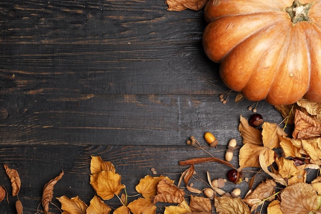 Herfstcompositie met droge bladeren en rijpe pompoenen op een donkere houten tafel Bovenaanzicht Kopieer de ruimte