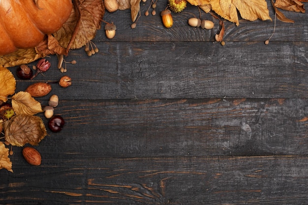 Herfstcompositie met droge bladeren en rijpe pompoenen op een donkere houten tafel Bovenaanzicht Kopieer de ruimte