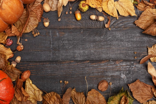 Herfstcompositie met droge bladeren en rijpe pompoenen op een donkere houten tafel Bovenaanzicht Kopieer de ruimte