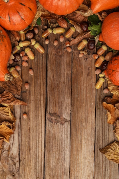 Herfstcompositie met droge bladeren en rijpe pompoenen op een houten tafel bovenaanzicht kopieer de ruimte