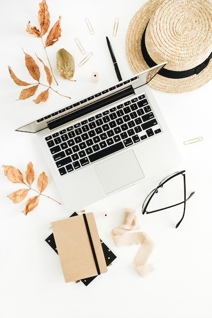 Herfstcompositie met laptop, agenda, stro en droge herfstbladeren. Platliggend, bovenaanzicht