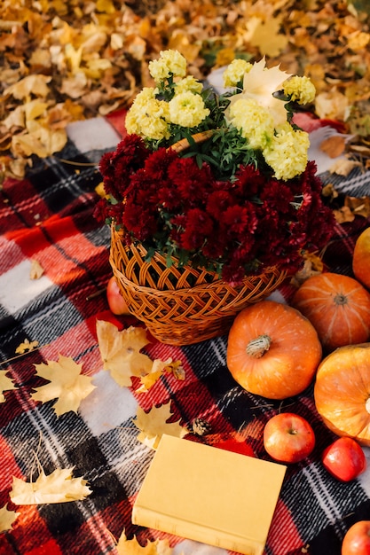 Herfstcompositie met pompoenen esdoorn bladeren en rode appels en bloemen