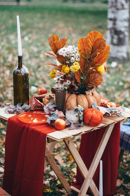 Herfstdecortafel in de natuur met pompoenkaarsen en bloemen