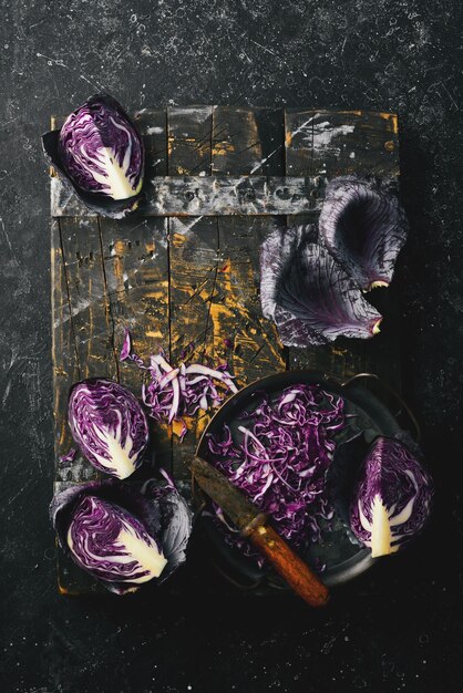 Herfstgroenten Vers gesneden paarse kool in een metalen dienblad op een zwarte stenen achtergrond