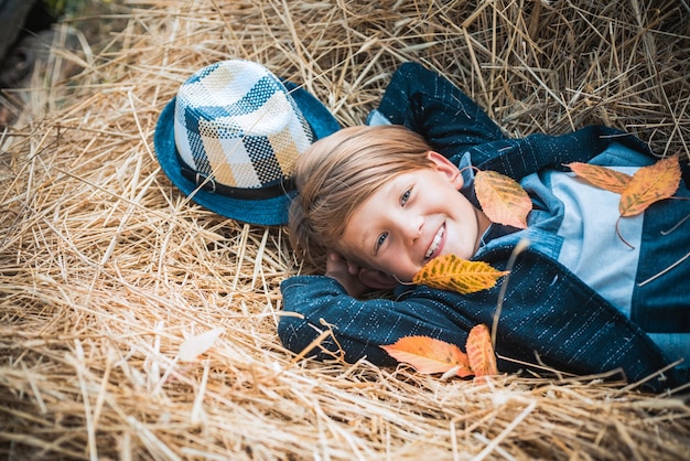 Herfstkleding en kleur kindertrends jongen op een briesje in een herfstdorp herfstkind jongen met herfststemming advertentieconcept