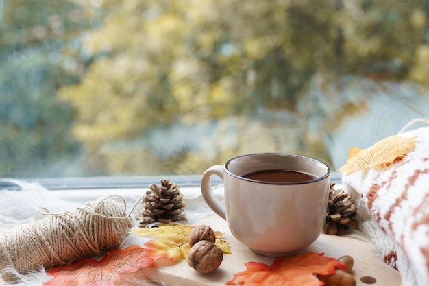Foto herfstkop koffie op houten achtergrond met vallende bladeren