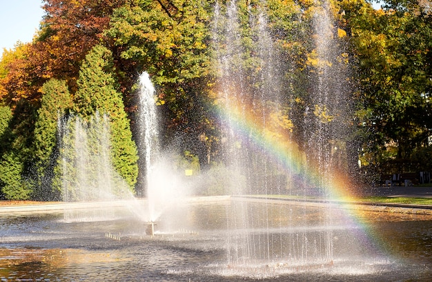 Herfstlandschap met een prachtige regenboog in een fontein