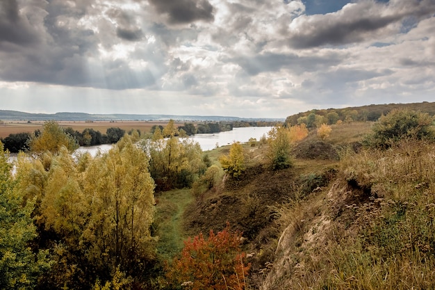 Foto herfstlandschap met uitzicht op de rivier door het bos en de rotsen