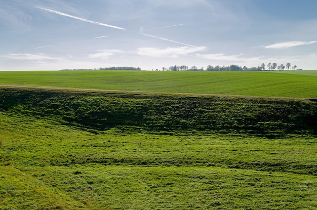 Foto herfstlandschapsveld op een zonnige dag patroon van vliegtuigsporen van gecondenseerde lucht die elkaar kriskras doorkruisen