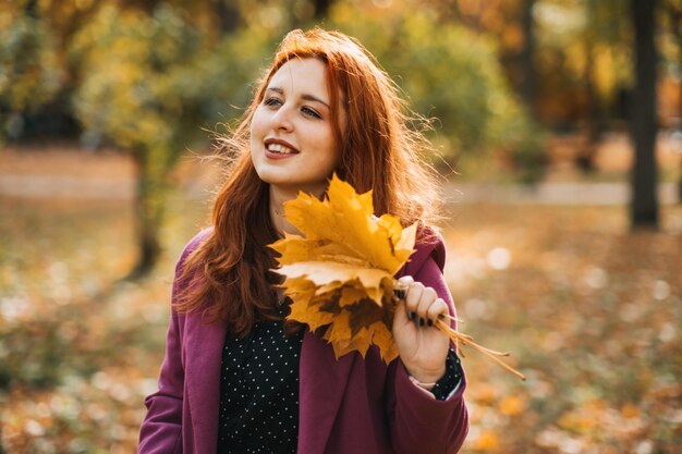 Herfstmode aardetinten stijl helder herfstkleurenpalet portret van roodharig meisje in paarse jas