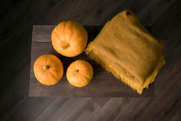 Herfstpompoenen en een deken op een houten tafel