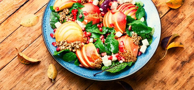 Herfstsalade met appel, groen, havermout en kaas. Schoon eten op rustieke houten tafel