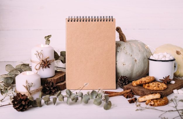 Herfstsamenstelling mockup cacao marshmallows koekjes pompoen en kaarsen