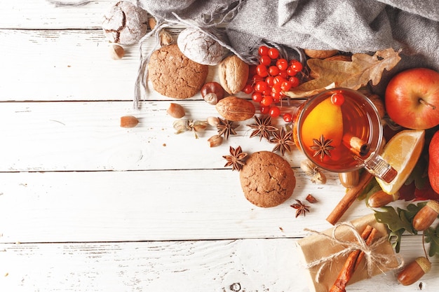 Herfstsamenstelling van een kopje verwarmende thee herfstbladeren fruit en kruiden op een witte houten tafel Bovenaanzicht Kopieer de ruimte