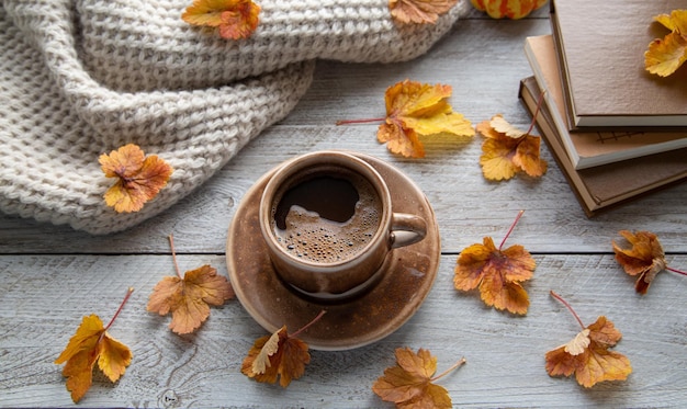 Herfststemming herfstsfeer Een kopje koffie een gebreide sjaal boeken en herfstbladeren op de vensterbank