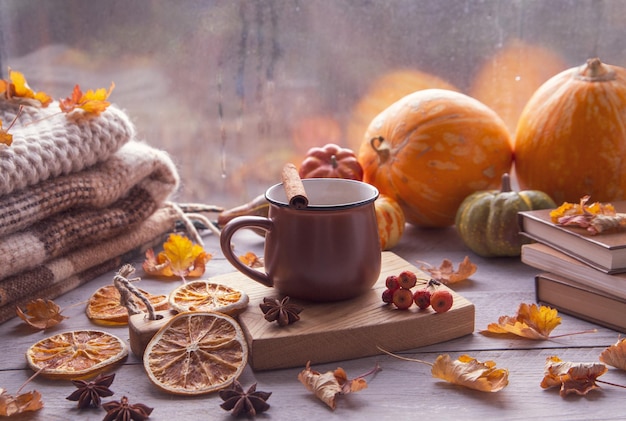 Herfststemming herfstsfeer Een kopje koffie pompoenen gebreide warme dekens boeken herfstbladeren op de vensterbank