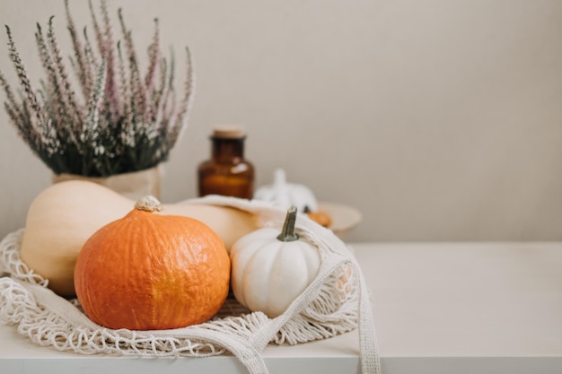 Herfststilleven met pompoenen erin en gouden bladeren op een houten ondergrond herfstpompoen thanksgiving