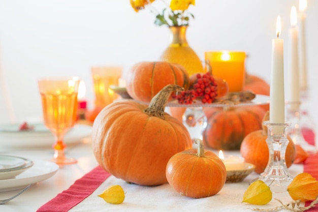 Herfsttafel met brandende kaarsen en pompoenen