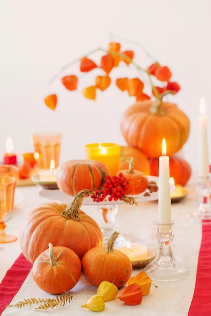 Herfsttafel met brandende kaarsen en pompoenen