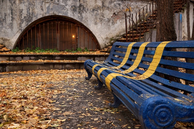 Herfsttafereel met een bankje in de tuin van het oude huis