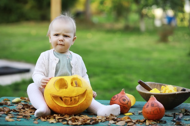 Herfsttradities en voorbereidingen voor de vakantie Halloween. Een huis in de natuur, een lamp gemaakt van pompoenen knipt uit aan tafel.