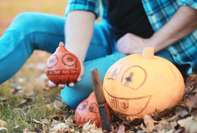 Herfsttradities en voorbereidingen voor de vakantie Halloween. Een huis in de natuur, een lamp gemaakt van pompoenen knipt uit aan tafel.