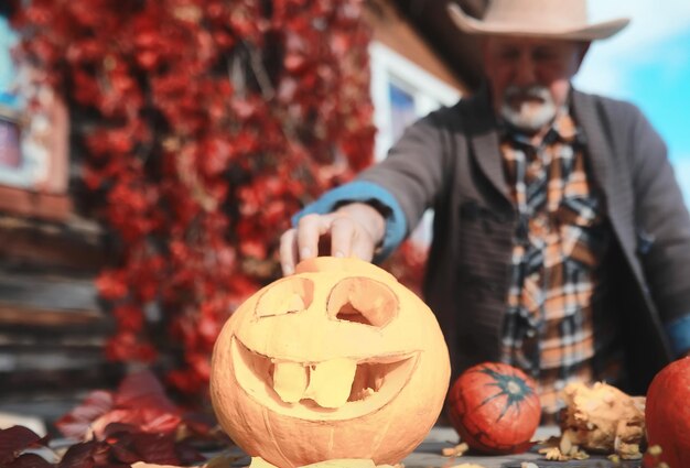 Herfsttradities en voorbereidingen voor de vakantie Halloween. Een huis in de natuur, een lamp gemaakt van pompoenen knipt uit aan tafel.