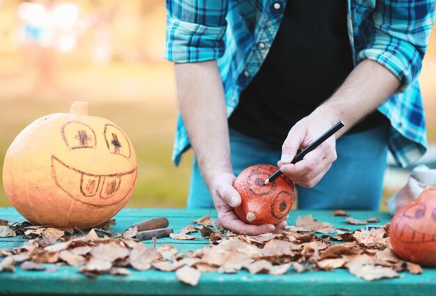 Herfsttradities en voorbereidingen voor de vakantie halloween. een huis in de natuur, een lamp gemaakt van pompoenen knipt uit aan tafel.