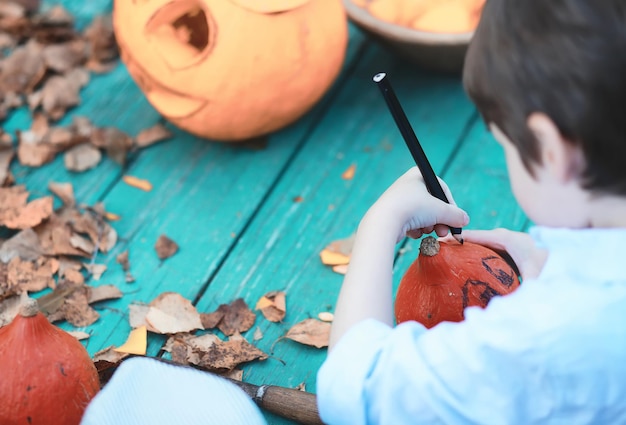 Herfsttradities en voorbereidingen voor de vakantie halloween. een huis in de natuur, een lamp gemaakt van pompoenen knipt uit aan tafel.