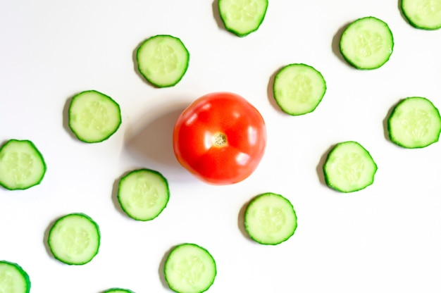 herhalend patroon van gesneden verse rauwe groentekomkommers voor salade en een hele tomaat