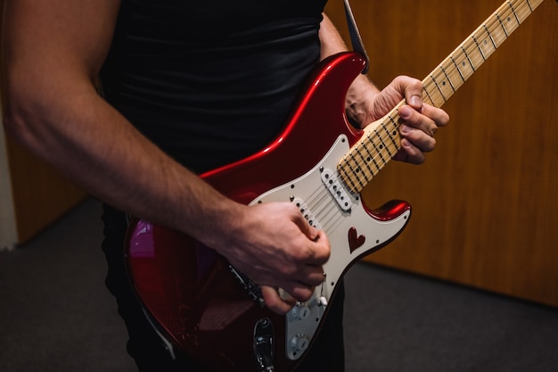 Foto herhaling van een rockband in de studio bijgesneden afbeelding van een elektrische gitarist