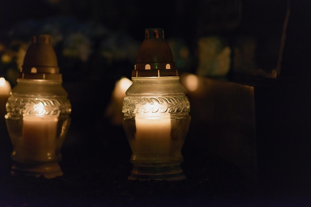 Herinneringslantaarn met brandende kaars in het donkerWitte kaarsen Branden in de donkere nacht met gloeiende lichtenFocus op kaarsen op de voorgrond