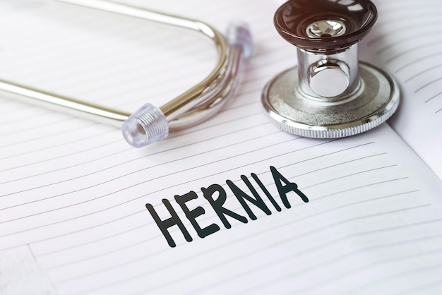 HERNIA Text on a medical card next to a pen stethoscope