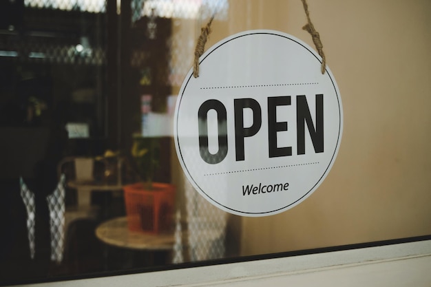 Heropen koffie café winkel tekst op vintage bord hangend aan glazen deur in café winkel heropenen nadat coronavirus quarantaine voorbij is in restaurant klaar om klein bedrijf eigenaar concept te bedienen