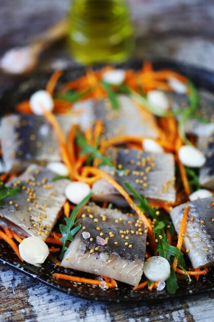 Herring fillet pieces marinated with spices on a plate