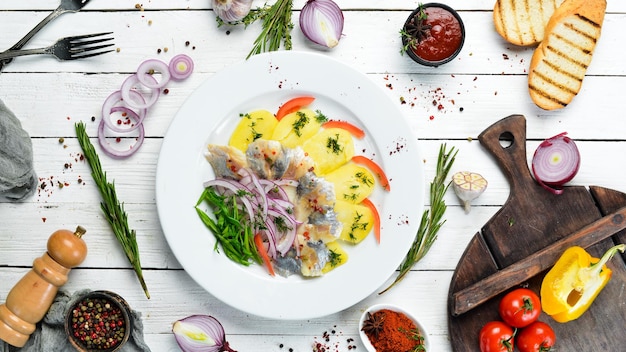 Herring with potatoes and onions on a plate Ukrainian traditional cuisine Top view Free space for your text