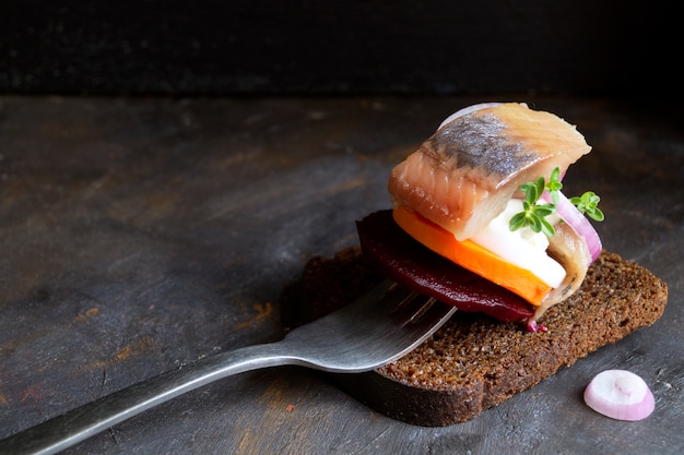 Herring with vegetables on a fork.