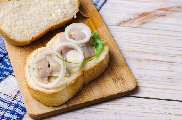 Herring with white onion on a piece of bread