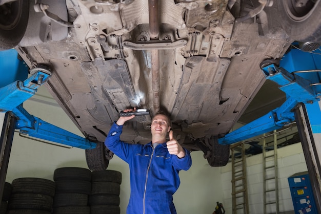 Hersteller onder auto gesturing duimen omhoog