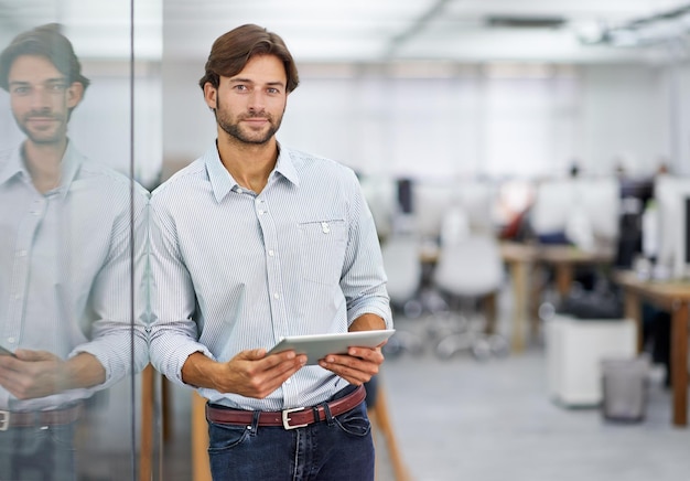 Hes a confident young businessman Portrait of a handsome young businessman standing in his office